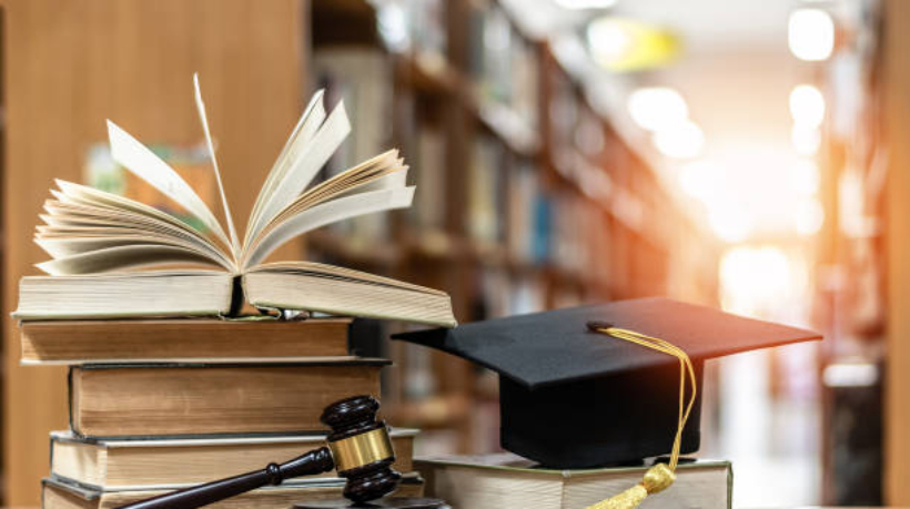 Law education, legal educational study, school for lawyer, legistration, litigation, judicial knowledge learning concept with court judge gavel and textbook with mortarboard on books in library
